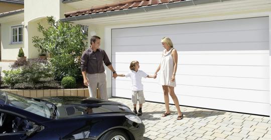 Familie mit Auto vor der Garage